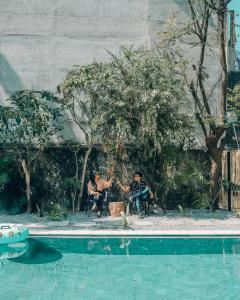 two men sitting in chairs next to a swimming pool at Casa Amaranto in Panajachel