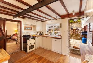 a kitchen with white cabinets and a stove top oven at Southcott Farm Cottage in Honiton