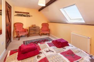 a bedroom with a bed and two chairs and a window at Southcott Farm Cottage in Honiton