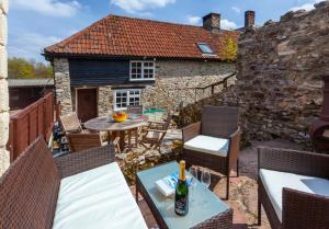 a patio with a table and chairs and a building at Southcott Farm Cottage in Honiton