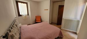 a bedroom with a bed and an orange chair at Lovely apartment in center of Barzio in Barzio