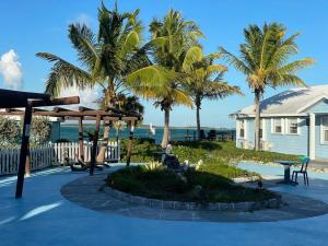 a patio with palm trees and a house at Beautiful Villa just steps away from the beach! in Georgetown