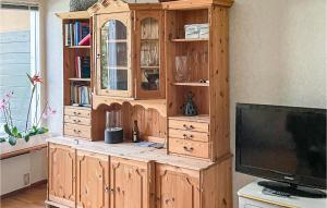 un centro de entretenimiento de madera en una sala de estar con TV en 2 Bedroom Cozy Home In Virsbo, en Virsbo Bruk