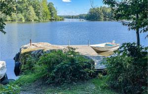 a boat sitting on a dock on a lake at 2 Bedroom Cozy Home In Virsbo in Virsbo Bruk