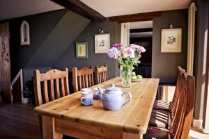 uma mesa de madeira com um vaso de flores em Crossroads Farm - Queen Anne's Stable em Box