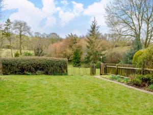 a garden with a fence and a grass yard at Regina Cottage in Bradpole