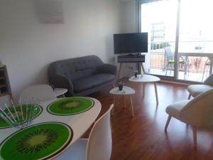 a living room with tables and chairs and a television at Studio Arcachon, 1 pièce, 2 personnes - FR-1-374-104 in Arcachon