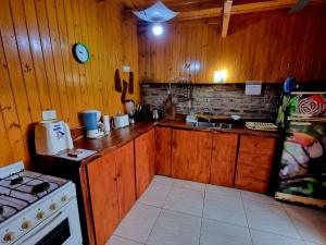 cocina con paredes de madera, fogones y encimera en La Morada del Sol en Puerto Iguazú