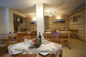 a dining room with a table and chairs with wine glasses at U Gruloka in Poronin