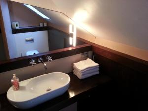 y baño con lavabo blanco y espejo. en Krakow Jacuzzi Apartment, en Cracovia