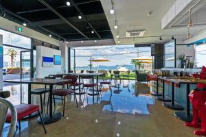 restauracja ze stołami i krzesłami oraz dużym oknem w obiekcie Gold Beach Resort w mieście Yeosu
