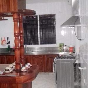 a kitchen with wooden cabinets and a stove top oven at Hostal My House Your House in David