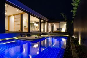 a swimming pool in the middle of a house at night at Villoft Zen Living Resort in Thalang