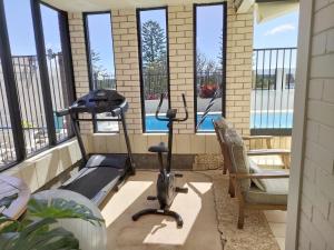 a room with a treadmill and a chair on a balcony at Citadel Suite in Port Macquarie