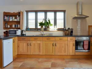 a kitchen with wooden cabinets and a white appliance at The Wests in Lastingham