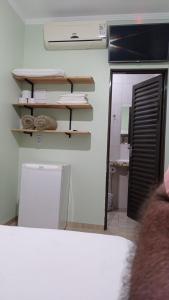 a room with a bathroom with a mirror and a sink at Pousada Menina Moça in Olímpia