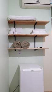 a shelf with two donuts on top of a refrigerator at Pousada Menina Moça in Olímpia
