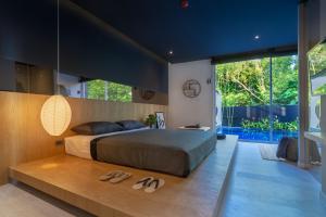 a bedroom with a bed and two pairs of slippers at Villoft Zen Living Resort in Thalang