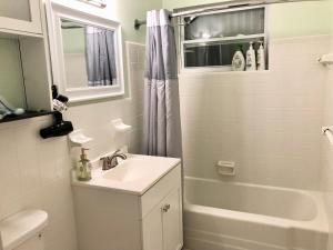 a white bathroom with a sink and a shower at Sunset Charlotte - Home away from home in Port Charlotte