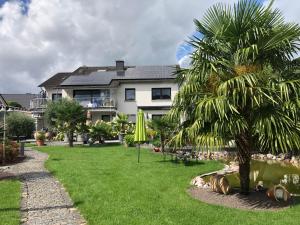 a house with a palm tree in front of a yard at Ferienwohnung am Pferdemarkt in Konz