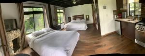 two beds in a room with a kitchen and a kitchen at El Granero De Frida in Boquete