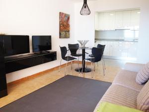 a living room with a tv and a table and chairs at ApartUP La Concha Beachfront I in Oropesa del Mar