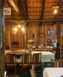 ein Esszimmer mit einem Tisch und Stühlen sowie Holzwänden in der Unterkunft Pousada Chalés do Rancho Canastra in Vargem Bonita