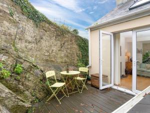 a patio with a table and chairs next to a wall at Larboard in Fowey