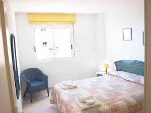 ein Schlafzimmer mit einem Bett und einem Stuhl und einem Fenster in der Unterkunft ApartUP Spectacular Beach View in Oropesa del Mar