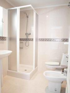ein weißes Badezimmer mit Dusche und Toilette in der Unterkunft ApartUP Spectacular Beach View in Oropesa del Mar + 16 Fotos