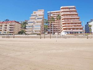 ein großer leerer Strand mit Gebäuden im Hintergrund in der Unterkunft ApartUP Spectacular Beach View in Oropesa del Mar