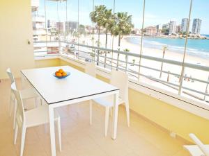 ein Esszimmer mit einem weißen Tisch und Strandblick in der Unterkunft ApartUP Spectacular Beach View in Oropesa del Mar