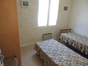 Duas camas num quarto com uma janela em Maison Royan, 4 pièces, 6 personnes - FR-1-71-52 em Royan