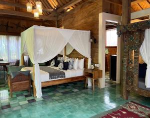a bedroom with a bed with a canopy at Umakayu Joglo Villa Canggu - Boutique Hotel in Canggu