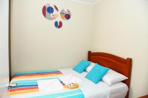 Una cama con almohadas coloridas y un corazón en la pared. en Apartamento Hermoso en Residencial - Huacachina en Ica