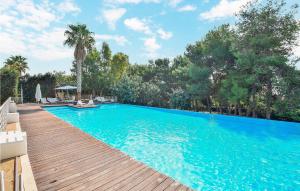 einen großen blauen Pool mit Holzterrasse in der Unterkunft Nice Home In Marina Di Ragusa With Wifi in Marina di Ragusa + 12 Fotos