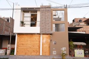 a house with a wooden garage door at Apartamento Hermoso en Residencial - Huacachina in Ica