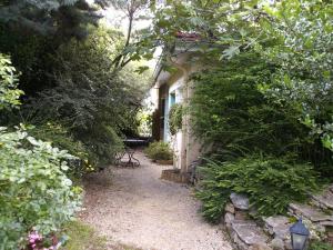 a garden path leading to a house with bushes at Chambre D'Hotes Au Coquelicot in Soucieu-en-Jarrest