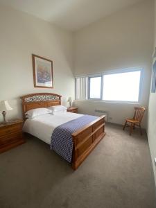 a bedroom with a large bed and a window at Woodsmoke Two Falls Creek in Falls Creek