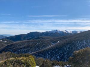 a view of a mountain range with snow capped mountains at Woodsmoke Two Falls Creek in Falls Creek