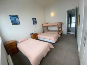 a room with two beds and a bunk bed at Woodsmoke Two Falls Creek in Falls Creek