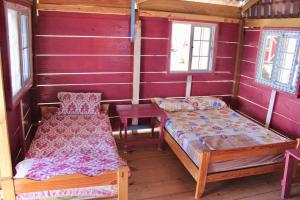 WaisalatupoにあるPrivate Over-Water Cabin on paradise San Blas islandのベッド2台と窓2つが備わる小さな客室です。
