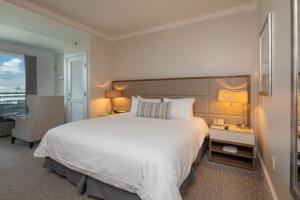 a bedroom with a large white bed and a chair at One-Bedroom Apartment in Miami Beach