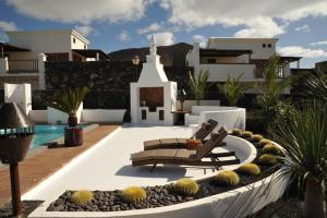 a view of a villa with a bench and a church at Villa Calero in Playa Blanca