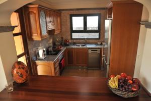 uma cozinha com armários de madeira e uma taça de fruta em Villa Calero em Playa Blanca