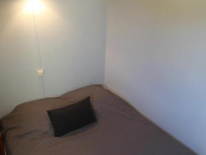 - une petite chambre avec un lit et un oreiller noir dans l'établissement Appartement La Roche-Posay, 2 pièces, 3 personnes - FR-1-541-23, à La Roche-Posay
