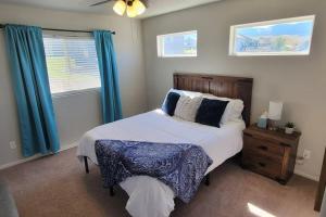 a bedroom with a large bed with blue curtains at 3 bed 2.5 bath smart home with rv parking in Casper