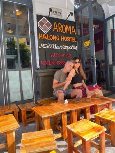 a man and woman sitting on a table outside a restaurant at AROMA Ha Long Hotel in Ha Long