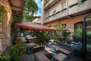 an outdoor patio with tables and chairs and an umbrella at Maison Borella in Milan