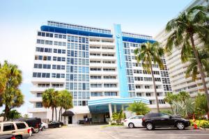 un grand bâtiment avec des voitures garées dans un parking dans l'établissement Ocean Manor Beach Resort, à Fort Lauderdale